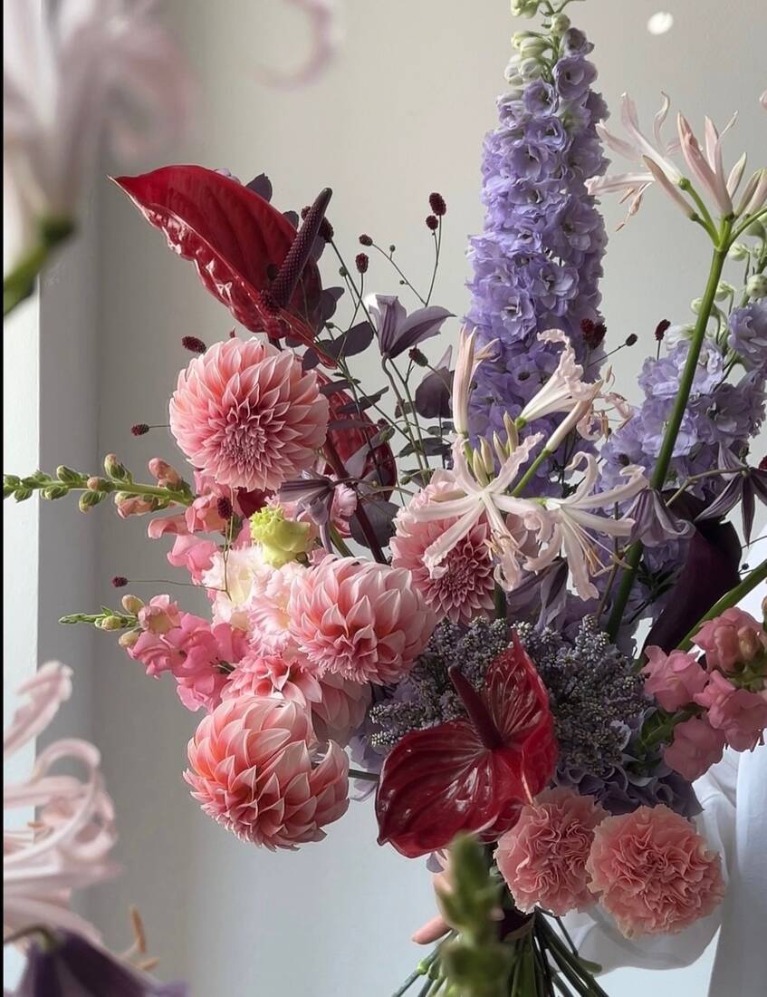 Close arrangement of pink dahlias and lavender delphinium