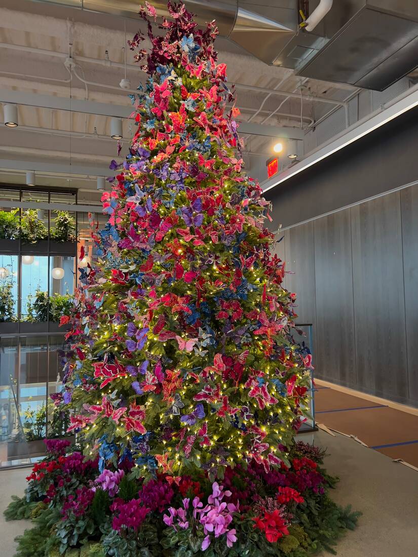 Holiday tree layered with hundreds of red, magenta, and violet butterflies
